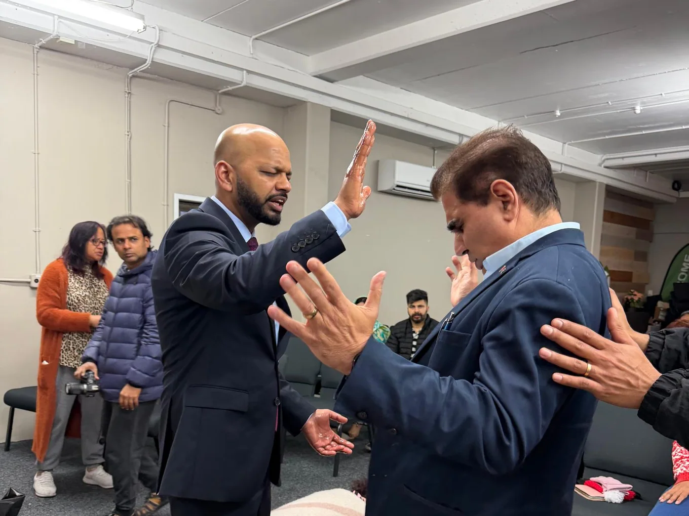 Pastor Vikas praying over a member of the church
